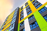 Facade fragment of new bright colorful modern residential building [IBR124036432]