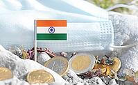 Indian flag with euro currency coins and a medical mask on rocky ground.International healthcare costs, cross-border medical funding, India and Europe cooperation and global health finance [IBR124084101]