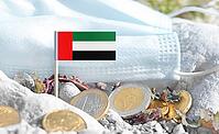 United Arab Emirates flag with euro currency coins and a medical mask on rocky ground.International healthcare costs, medical funding, Europe and UAE cooperation and global health finance [IBR124084102]