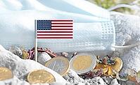 American flag with euro currency coins and a medical mask on rocky ground.International healthcare costs, medical funding, Europe and USA cooperation and global health finance [IBR124084103]