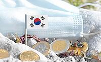 South Korea flag with euro currency coins and a medical mask on rocky ground.International healthcare costs, cross-border medical funding, Europe and Korean cooperation and global health finance [IBR124084104]