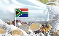 South Africa flag with euro currency coins and a medical mask on rocky ground.International healthcare costs, cross-border medical funding, Europe and South Africa cooperation and global health finance [IBR124084106]
