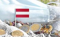 Austrian flag with euro currency coins and a medical mask on rocky ground.Eurozone healthcare costs, medical funding challenges and the financial weight of modern services connected to Austria [IBR124084111]