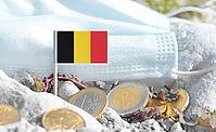 Belgium flag with euro currency coins and a medical mask on rocky ground.Eurozone healthcare costs, medical funding challenges and the financial weight of modern services connected to Belgium [IBR124084113]