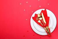Romantic table setting, gold cutlery on the red table cloth. Valentine's day celebration [IBR124084183]