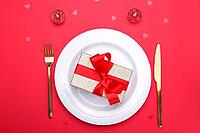Romantic table setting, gold cutlery on the red table cloth. Valentine's day celebration [IBR124084184]
