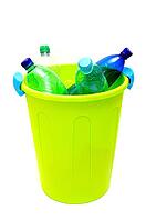 Green garbage bin filled with plastic bottles against white background [IBR124192771]