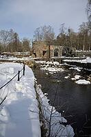 The ruins of the historic Borgvik Ironworks. Industrial stone architecture on a river in winter with snow and blue skies. Cultural heritage site in picturesque countryside in Värmland, Sweden [IBR124200519]