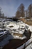 The ruins of the historic Borgvik Ironworks. Industrial stone architecture on a river in winter with snow and blue skies. Cultural heritage site in picturesque countryside in Värmland, Sweden [IBR124200526]