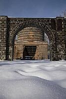 The ruins of the historic Borgvik Ironworks. Industrial stone architecture on a river in winter with snow and blue skies. Cultural heritage site in picturesque countryside in Värmland, Sweden [IBR124200530]