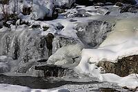 The ruins of the historic Borgvik Ironworks. Industrial stone architecture on a river in winter with snow and blue skies. Cultural heritage site in picturesque countryside in Värmland, Sweden [IBR124200532]