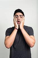 Studio shot of young handsome bearded Indian man against white background [IBR124309003]