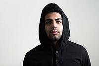 Studio shot of young handsome bearded Indian man against white background [IBR124309006]