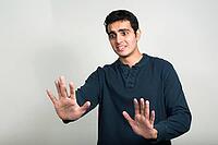 Studio shot of young handsome Indian man against white background [IBR124309008]