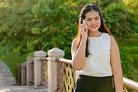Portrait of young beautiful Asian woman relaxing at the park outdoors [IBR124309018]