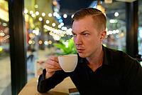 Portrait of young handsome Scandinavian businessman relaxing at the coffee shop [IBR124309024]