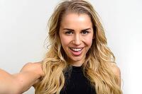 Studio shot of young beautiful woman with blonde wavy hair against white background [IBR124309032]