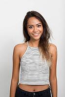 Studio shot of young beautiful Asian woman with brown hair against white background [IBR124309035]
