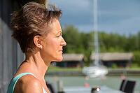 Portrait of mature beautiful woman with short hair at restaurant by the pier outdoors [IBR124309050]