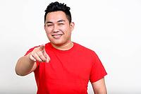 Studio shot of young handsome overweight Filipino man against white background [IBR124309065]
