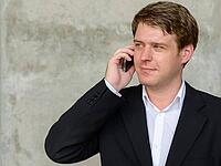 Portrait of young handsome Scandinavian businessman against concrete wall in the city outdoors [IBR124309068]