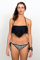 Studio shot of young beautiful tourist woman with curly hair in bikini ready for vacation against white background [IBR124309070]