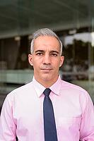 Portrait of handsome Persian businessman with gray hair outside modern building in the city [IBR124309075]