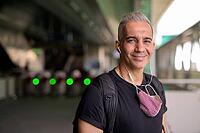 Portrait of Persian man with mask for protection from corona virus outbreak and pollution at the sky train station [IBR124309080]