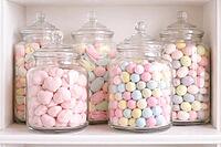 Pastel-colored candies stacked on a shelf in clear glass containers, pastel-colored candy, AI generated [IBR124458861]