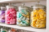 Various colorful fabric ribbons and bows in glass containers on a shelf, DIY material, neatly sorted, storage and organization system for hobbies and creative craft projects, AI generated [IBR124458869]