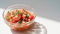 Glowing tomato salad with herbs under soft sunlight in a bowl, hearty party salad, beautifully presented in a glass, AI generated [IBR124458881]