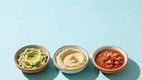 Three bowls of guacamole, hummus and salsa on a blue background, delicious dip, perfect as a side dish for meals and parties, AI generates, AI generated [IBR124458891]
