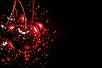 Close-up of red cherries with drops of water against black background, healthy food, AI generated [IBR124458905]