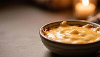 A bowl of melted cheese in a cozy, warm candlelight, delicious dip, perfect as a side dish for meals and parties, AI generates, AI generated [IBR124458907]