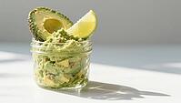 Fresh guacamole in a glass with half an avocado and lime wedge in sunlight, delicious dip, perfect as a side dish for meals and parties, AI generates, AI generated [IBR124458914]