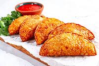 Fried mini chebureks, close-up, on a wooden chopping board, light background, no people [IBR124476266]