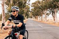 Woman cyclist sitting on her bike resting during outdoors ride [IBR124491542]