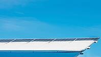 Solar panels covered in snow against a clear blue sky generate clean energy, even in the winter season [IBR124491597]