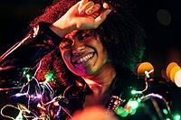 Happy woman posing at night with colored and christmas lights [IBR124491600]