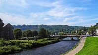 River under a bridge surrounded by lush greenery and hills, quiet summer atmosphere, Aywaille, Belgium [IBR124491606]