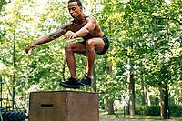 Young athletic male doing box jump on sports ground [IBR124491610]