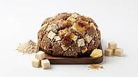 A wholesome energy ball made with oats, nuts, and seeds, topped with a rich caramel glaze and served with cubed ingredients and a pile of powder, AI generated [IBR124494040]