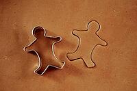 Raw rolled dough for ginger cookies with cutter in shape of man. Traditional sweets for winter holidays [IBR124497421]