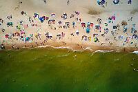 Aerial view of sea landscape with crowded sand beach in Wladyslawowo. Baltic sea coastline with swimming people in Poland. Resort town in summer season [IBR124497426]