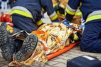 Rescuers provide first aid to the victim during a car accident. Person injured in the accident is lying on the road [IBR124497428]