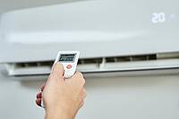 Hand adjusting temperature on air conditioner with remote control, Working air conditioner for comfort temperature in home at hot summer [IBR124497432]