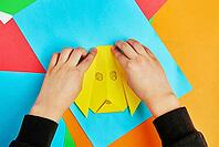 Boy hands making origami dog with colorful paper sheets, Child creative education [IBR124497444]