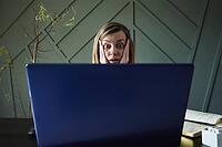 Shocked woman looking at laptop screen with rounding eyes. Excited emotional reaction at online news [IBR124497456]