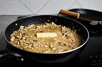 Process of cooking risotto. Arborio rice and piece of butter in frying pan in home kitchen. Italian cuisine dish [IBR124497478]