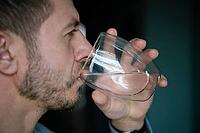 Man drinks water, Close-up shot of bearded man drinking fresh clean water from glass, Quenching thirst, Lifestyle healthcare concept [IBR124497492]